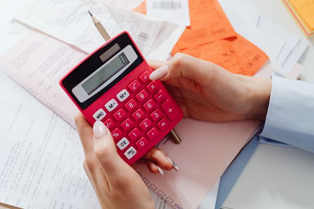 A property owner using a calculator to determine management costs.